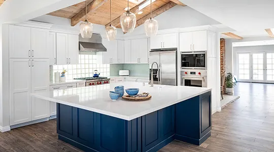 Modern kitchen with blue island and pretty light decoration.