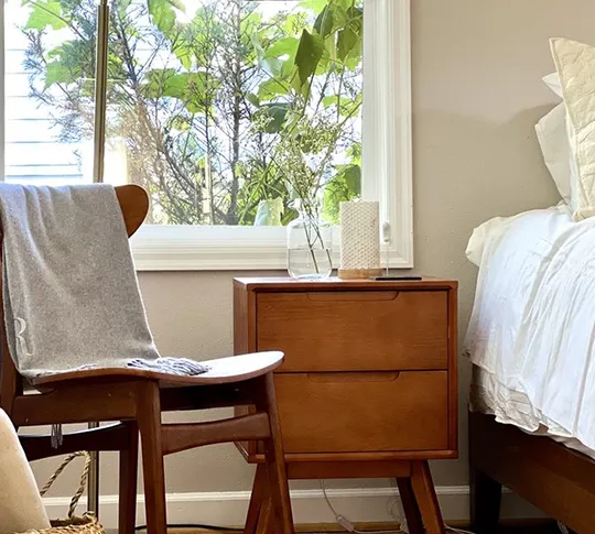 Bedroom corner featuring a chair and bedside table.